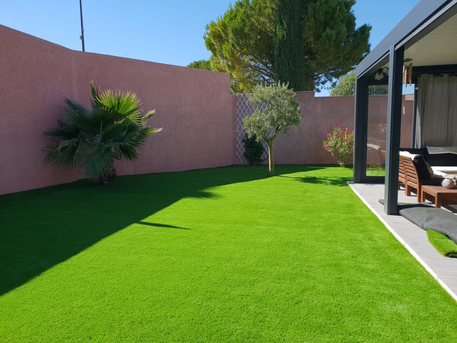 Jardin aménagé avec un gazon synthétique après la pose