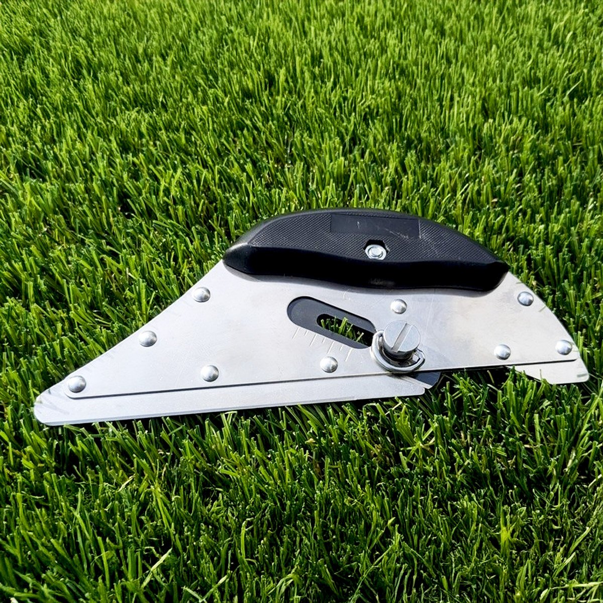 Cutter de précision posé sur un gazon synthétique avant les découpes